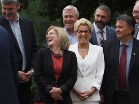 Alberta Premier Rachel Notley and Ontario Premier Kathleen Wynne have a laugh together while waiting for a group photo of the premiers during the Council of Federation meetings in Edmonton Alta, on Tuesday July 18, 2017. THE CANADIAN PRESS/Jason Franson