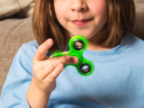 A young girl plays with a fidget spinner toy in this stock photo. (Getty Images)