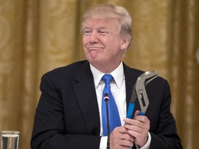 U.S. President Donald Trump holds a Channellock tool during a meeting with company representatives and featuring products made in the United States, in the East Room of the White House on July 19, 2017 in Washington. (Michael Reynolds/Pool/Getty Images)
