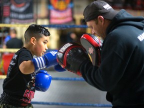 Miguel Estrada, 8, practices combinations with his boxing coach Rob Caron last year at Warrior?s Boxing and Fitness. (The London Free Press)