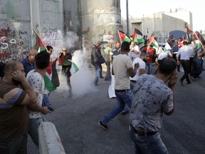 Palestinians run away from stun grenades thrown by Israeli border police officers during a protest against the metal detectors placed at the entrance to the Al Aqsa Mosque compound, in the West Bank city of Bethlehem, Wednesday, July 19, 2017. (AP Photo/Mahmoud Illean)