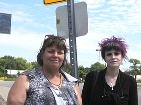 Terry Anderson, left, poses alongside Anastasia Wilson at a bus stop for route nine in Sarnia. Several residents are opposing service reductions during the summer. (Tyler Kula/Sarnia Observer/Postmedia Network)
