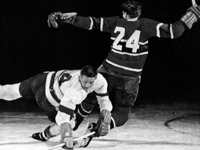 Dutch Reibel #14 of the Detroit Red Wings checks Dick Gamble #24 of the Montreal Canadiens during their game circa 1950s at the Montreal Forum in Montreal, Quebec, Canada. (Bruce Bennett Studios/Getty Images)