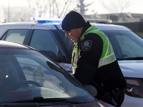 Community Peace Officer Jeremy Boese talks to a motorist in a traffic stop on 100 Street in front of the Daily Herald Tribune office on Wednesday January 25, 2017 in Grande Prairie, Alta. Kevin Hampson/Grande Prairie Daily Herald-Tribune/Postmedia Network