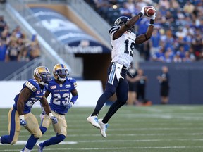 Toronto Argonauts' S.J. Green grabs a high throw in front of a pair of Winnipeg Blue Bomber defenders during CFL action in Winnipeg on July 13, 2017. (Kevin King/Winnipeg Sun/Postmedia Network)