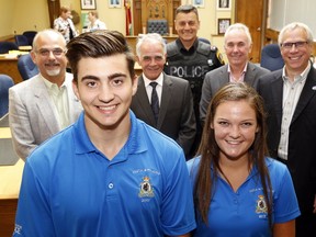 Belleville Police summer students Brock Abbott and Makenna Clayton get the backing of the Belleville Police Services Board Thursday, July 20, 2017 at city hall in Belleville, Ont. Both have held several volunteer positions with other organizations. Behind them from left were mayor and board chairman Taso Christopher, vice-chairman Brad Devolin, Chief Ron Gignac, provincial appointee Tom Lafferty and member and city councillor Jack Miller. Luke Hendry/Belleville Intelligencer/Postmedia Network