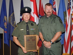 Grande Cache district officer Shane Ramstead, left, receives the North American wildlife officer of the year award from North American Wildlife Enforcement Officers Association vice-president Shawn Farrell on July 18, 2017. Supplied