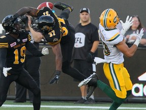 Hamilton Tiger-Cats defensive back Justin Rogers (left) watches teammate Richard Leonard leap to block a pass 
intended for Edmonton wide receiver Brandon Zylstra. Hamilton lost again and the Eskimos remained undefeated.The Canadian Press