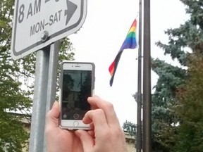A supporter photographs historic rainbow flag raising in 2016 at St. Thomas city hall. (File Photo