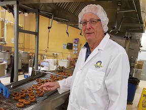 Kinnikinnick Foods' President and CEO Jerry Bigam checks out production of the food firms gluten-free chocolate donuts.
(Photo by Graham Hicks)