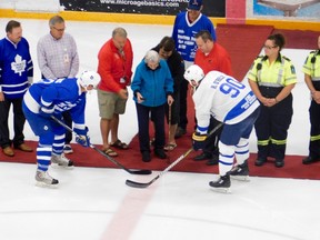 Boyd Devereaux (left) and Ryan O'Reilly (right) face off for the ceremonial opening puck drop, made by O'Reilly's grandmother.