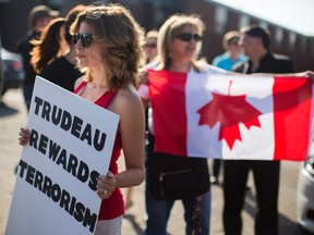 Protesters stand outside of Paramount Fine Foods before Prime Minister Justin Trudeau spoke at an event in Mississauga, Ont., Thursday, July 20, 2017. THE CANADIAN PRESS/Mark Blinch