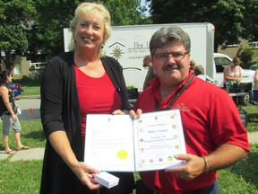 Sarnia-Lambton MP Marilyn Gladu presents a Canada 150 medallion to Myles Vanni, executive director of the Inn of the Good Shepherd, at one of the agency's mobile market stops  in Sarnia, Ont., Friday July 21, 2017. Gladu is awarding 20 of the medallions over the coming weeks to individuals and groups in recognition of their contributions to the community. (Paul Morden/Sarnia Observer)