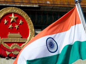 In this Oct. 23, 2013, file photo, an Indian national flag is flown next to the Chinese national emblem during a welcome ceremony for visiting Indian officials outside the Great Hall of the People in Beijing. (Andy Wong/The Associated Press)