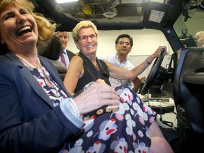 Ontario Premier Kathleen Wynne (centre, beside local MPP Nathalie Des Rosiers) toured Blackberry QNX Autonomous Vehicle Innovation Centre in Kanata Friday. Before fielding questions about Hydro One purchasing a company with interests in a coal plant, the Premier took a ride in QNX's driverless car - a Lincoln MKZ, capable of totally autonomous driving.
