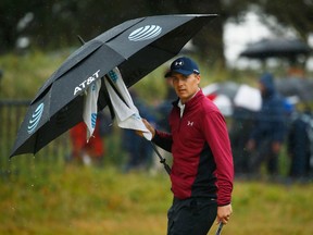 Jordan Spieth of the United States shelters from the rain under an umbrella during the second round of the 146th Open Championship at Royal Birkdale on July 21, 2017. (Gregory Shamus/Getty Images)