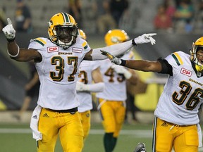 Edmonton Eskimos linebacker Kenny Ladler (37) celebrates with defensive back Arjen Colquhoun (36) after he intercepted a pass to end the game against the Hamilton Tiger-Cats during fourth quarter CFL football action in Hamilton, Ont., on Thursday, July 20, 2017.