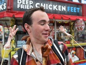 Reporter Dustin Cook trying his taste buds on chicken feet, deep fried of course at Chicky's Chicken which was one of the entrants at the New Fair Food Contest featuring all the new foods at this year's K-Days in Edmonton, July 21, 2017. Ed Kaiser/Postmedia