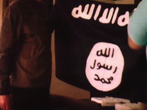 In this July 8, 2017 file image taken from FBI video and provided by the U.S. Attorney’s Office in Hawaii on July 13, 2017, Army Sgt. 1st Class Ikaika Kang holds an Islamic State group flag after allegedly pledging allegiance to the terror group at a house in Honolulu. (FBI/U.S Attorney’s Office, District of Hawaii via AP, File)