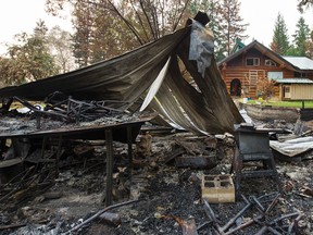 The charred remains of an out building is seen sitting in front a home saved by firefighters after the Soda Creek Fire jumped across the Fraser River near Alexandria, BC, July, 16, 2017. (Richard Lam/PNG)
