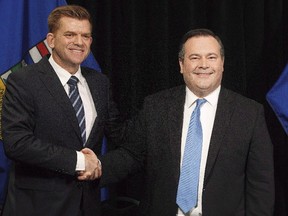 Alberta Wildrose leader Brian Jean and Alberta PC leader Jason Kenney shake hands after announcing a unity deal between the two in Edmonton on May 18, 2017. Albertans will find out today whether the province's two right-of-centre political parties will merge into one to try and defeat Premier Rachel Notley's NDP government. The Progressive Conservatives led by Jason Kenney and the Wildrose party led by Brian Jean will wrap up voting on a proposal to become the new United Conservative Party.