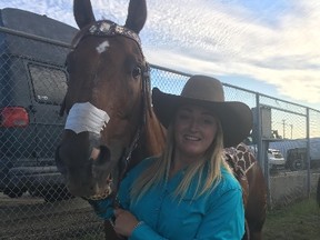 Sydney Daines poses with her horse, Flame, outside Northlands Coliseum in Edmonton on Saturday. Daines is competing in barrel racing at the K-Days rodeo. (Jason Hills)