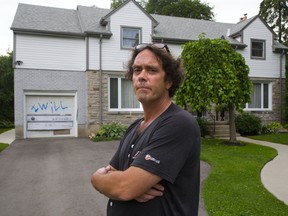 Bill Downe taped cardboard over his neighbour?s vandalized garage door on Talbot Street in London Sunday, after vandals spray-painted ?I will kill U?. In all, 30 Old North properties were defaced in the weekend spree. (DEREK RUTTAN, The London Free Press)
