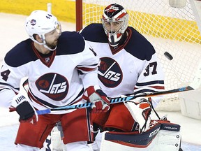 Winnipeg Jets goaltender Connor Hellebuyck tracks a puck tipped by defenceman Josh Morrissey against the Minnesota Wild in Winnipeg on Sun., March 19, 2017. On Monday, July 24, 2017, the Jets announced that Hellebuyck had signed a one-year, $2.25 million deal to avoid having to go to arbitration. Kevin King/Winnipeg Sun/Postmedia Network