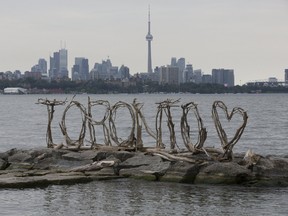 Local artists Thelia Sanders-Shelton and Julie Ryan used washed up driftwood to create a wooden Toronto sign on the rocks in Humber Bay on Monday July 24, 2017. (Stan Behal/Toronto Sun/Postmedia Network)