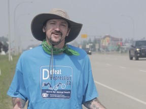 Mike Loughman walks along Highway 43 in Whitecourt on July 20 as part of a trek across the province to raise money for mental health supports (Joseph Quigley | Mayerthorpe Freelancer).