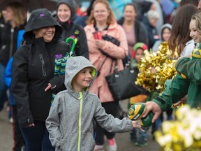 A participant at Monday Morning Magic gets a football from a representative of the Edmonton Eskimos. Monday Morning Magic is when when about 500 children between three and 12 years with special need are invited to K Days to enjoy the rides at their own pace, with local sports celebrities and professional athletes on July 24, 2017. Photo by Shaughn Butts / Postmedia