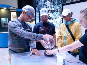 Stefan Hoetzl (second from left) and friends, all of Austria, check out the plasma ball at the Power of Ideas Tour at Science North, with the help of Power of Ideas crew member Ashley Turner, right, on Monday. The exhibit runs daily from 9 a.m. to 6 p.m. until Wednesday at Science North's Vale Cavern.(Keith Dempsey/For The Sudbury Star)
