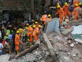 Rescuers work on the debris after a five-story building collapsed in the Ghatkopar area of Mumbai, India, Tuesday, July 25, 2017. A fire official says 11 people have been rescued and more are feared trapped.(AP Photo/Rafiq Maqbool)