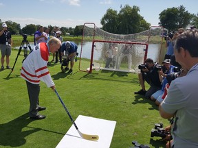 Golf legend Jack Nicklaus winds up to shoot a puck on a hockey net at Glen Abbey on July 25, 2017. (Dave Hilson/Postmedia)