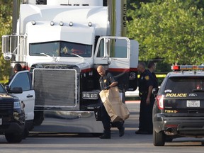 San Antonio police officers investigate the scene where ten people were found dead in a tractor-trailer outside a Walmart store in stifling summer heat in what police are calling a horrific human trafficking case, Sunday, July 23, 2017, in San Antonio. (AP Photo/Eric Gay)