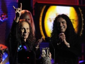In this April 8, 2010, file photo, Ronnie James Dio, left, celebrates after receiving the Best Vocalist award at the second annual Revolver Golden Gods Awards in Los Angeles. Rolling Stone reported July 26, 2017, that Dio, who died in 2010, would tour again in hologram form. (AP Photo/Chris Pizzello, File)