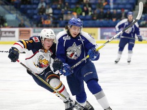 Tyler Tucker, left, of the Barrie Colts, and Ryan Valentini, of the Sudbury Wolves, chase after the puck during OHL action at Sudbury Community Arena in Sudbury, Ont. on Friday March 10, 2017. John Lappa/Sudbury Star/Postmedia Network