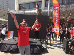 Manitoba Hydro CEO Kelvin Shepherd arrives at Manitoba Hydro Place with the Canada Games torch on Wednesday. (Jason Friesen/Winnipeg Sun/Postmedia Network)