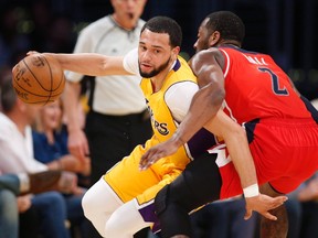 Los Angeles Lakers guard Tyler Ennis, left, attempts to dribble around Washington Wizards guard John Wall during the first half of an NBA basketball game on March 28, 2017. (THE CANADIAN PRESS)