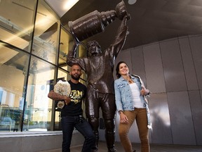 UFC flyweight champion Demetrious Johnson and women’s bantamweight champion Amanda Nunes pose for a photo beside the Wayne Gretzky statue outside Rogers Place during a media availability, in Edmonton Wednesday July 26, 2017.