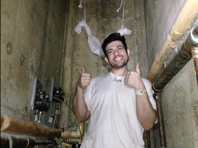 In this Jan. 22, 2016, image taken from a video released by attorney Salvatore P. Ciulla on Wednesday, July 26, 2017, on behalf of defendant Adam Hossein Nayeri, an escapee of the Orange County Jail, Nayeri gives a thumbs-up after crawling through a previously cut metal screen on a wall to reach plumbing shafts within the jail walls at the prison in Santa Ana, Calif. Video shot by three inmates with a smuggled cellphone shows their methodical escape through a vent at the maximum-security wing of the Southern California jail last year, along with scenes from their days on the run. (Salvatore P. Ciulla via AP)