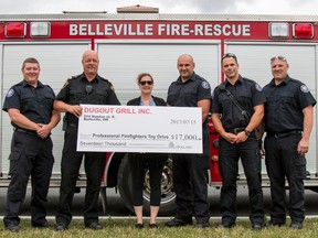Taylor Bertelink/The Intelligencer
Jennifer French (centre) presents Belleville firefighters with a $17,000 check Wednesday afternoon outside The Dugout. One-Hundred per cent of the funds will go to benefit the Belleville Professional Firefighters' Toy Drive.