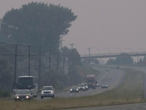 Cars and trucks drive though the thick smoke caused by wildfires just outside of Kamloops, B.C., on July 16, 2017. (THE CANADIAN PRESS/Jonathan Hayward)