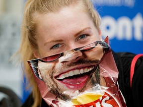 Canada's Joanna Brown goofs around with a potato chip bag while taking part in an ITU World Triathlon Edmonton press conference in Hawrelak Park, in Edmonton Thursday July 27, 2017.