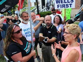 Premier Kathleen Wynne, right, speaks to demonstrator Jordan McGrail about the privatization of Hydro One during the politician's stop in Chatham, Ont. on Thursday July 27, 2017. (Ellwood Shreve/Chatham Daily News/Postmedia Network)