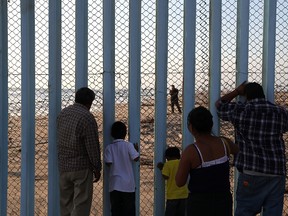 People look through the US-Mexican border fence at Playas de Tijuana during a Fourth of July gathering on the beach on July 4, 2017 in Tijuana, Mexico. (Justin Sullivan/Getty Images)