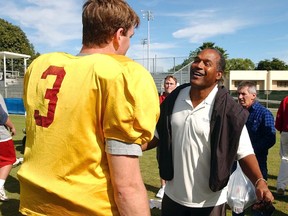 In this Dec. 28, 2002, file photo, USC quarterback Carson Palmer talks to O.J. Simpson after practice for the Orange Bowl in Davie, Fla. (AP Photo/J. Pat Carter, File)