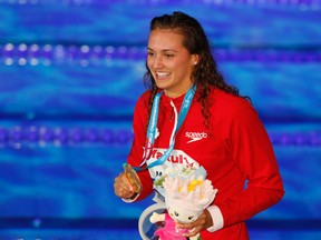 Canada's gold medal winner Kylie Jacqueline Masse shows off her medal after the women's 100-meter backstroke final during the swimming competitions of the World Aquatics Championships in Budapest, Hungary, Tuesday, July 25, 2017. (AP Photo/Darko Bandic)