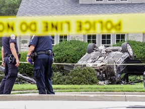 Police examine the scene of a car crash and shooting, Thursday, July 27, 2017 in Indianapolis. (Michelle Pemberton/The Indianapolis Star via AP)