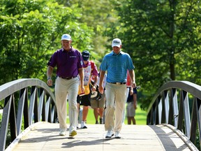 Ernie Els and Tom Hoge walk toward the 11th hole during the second round of the RBC Canadian Open at Glen Abbey Golf Club on July 28, 2017. (Vaughn Ridley/Getty Images)